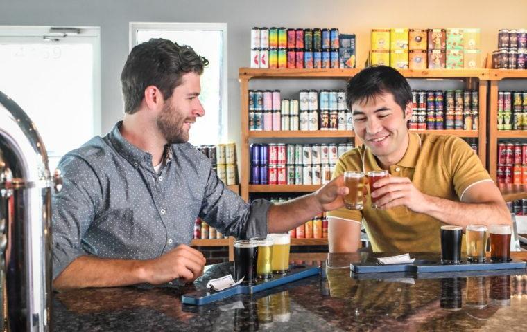 two people toast beer glasses